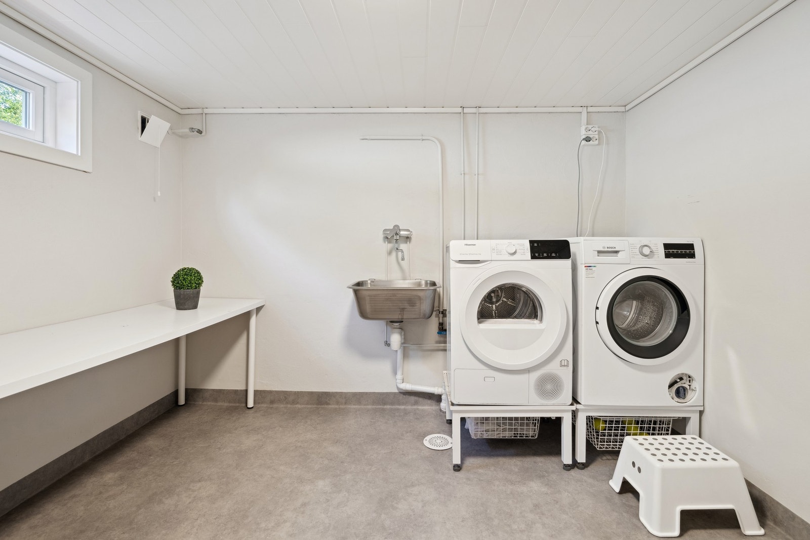 Stort vaskerom med utslagsvask, opplegg for både vaskemaskin og tørketrommel, samt gode arbeidsflater. Galleribilde