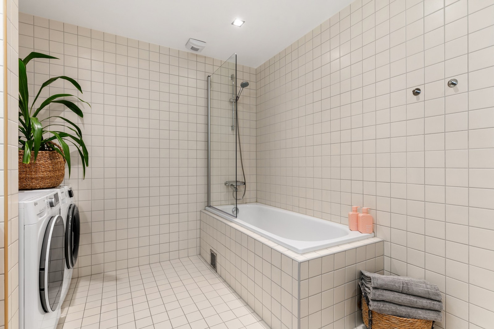 Badet er innredet med 2 nedfelte servanter med ettgreps armatur og skap/skuffeseksjon, vegghengt toalett og et innbygget badekar med glassvegg og dusjarmatur Galleribilde