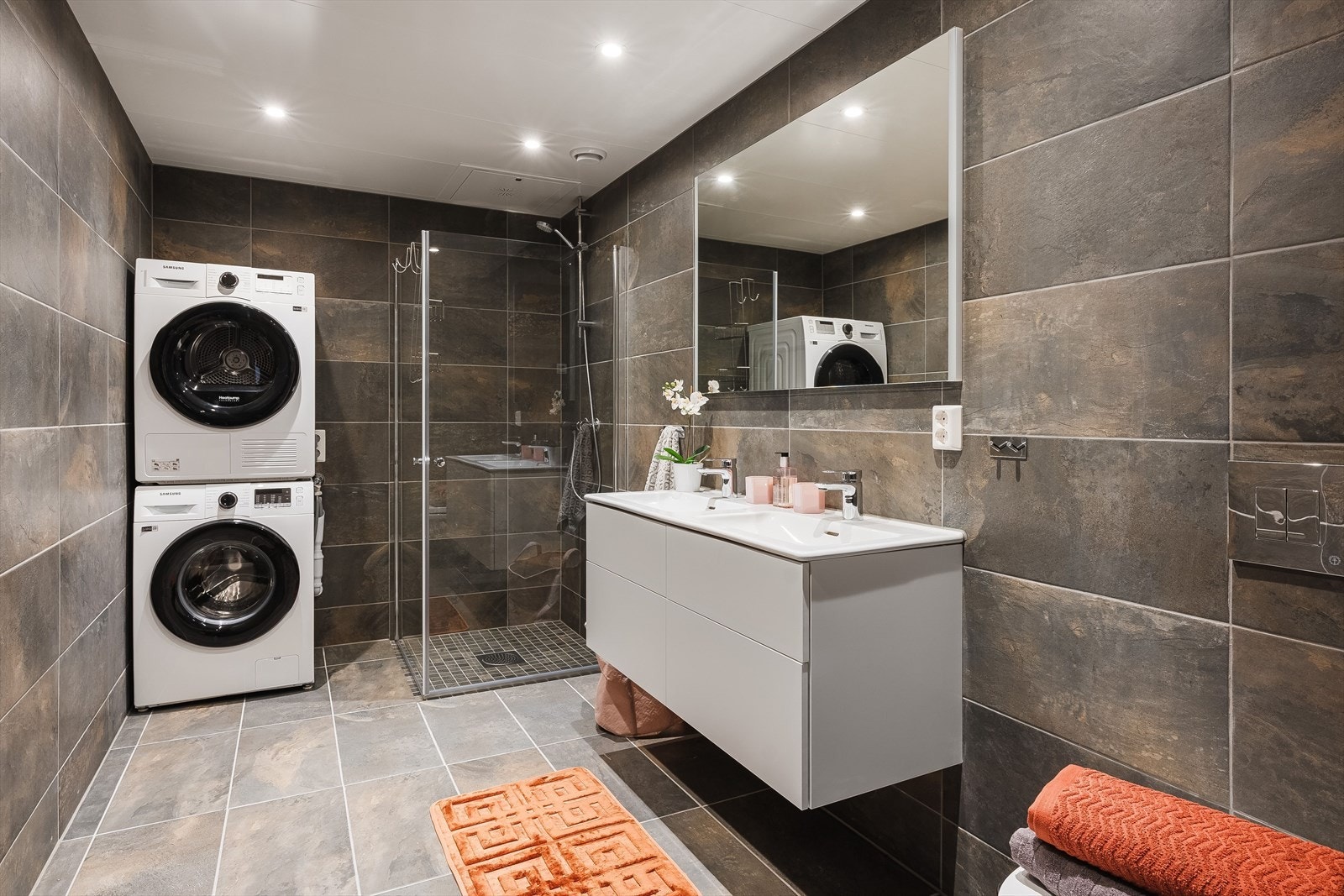 Baderom 2 er det største baderommet i leiligheten. Et stilrent og moderne baderom fra 2023 med flotte fliser på gulv og vegger, vannbåren gulvvarme, downlights i himlingen og mekanisk avtrekk via balansert ventilasjon. Galleribilde