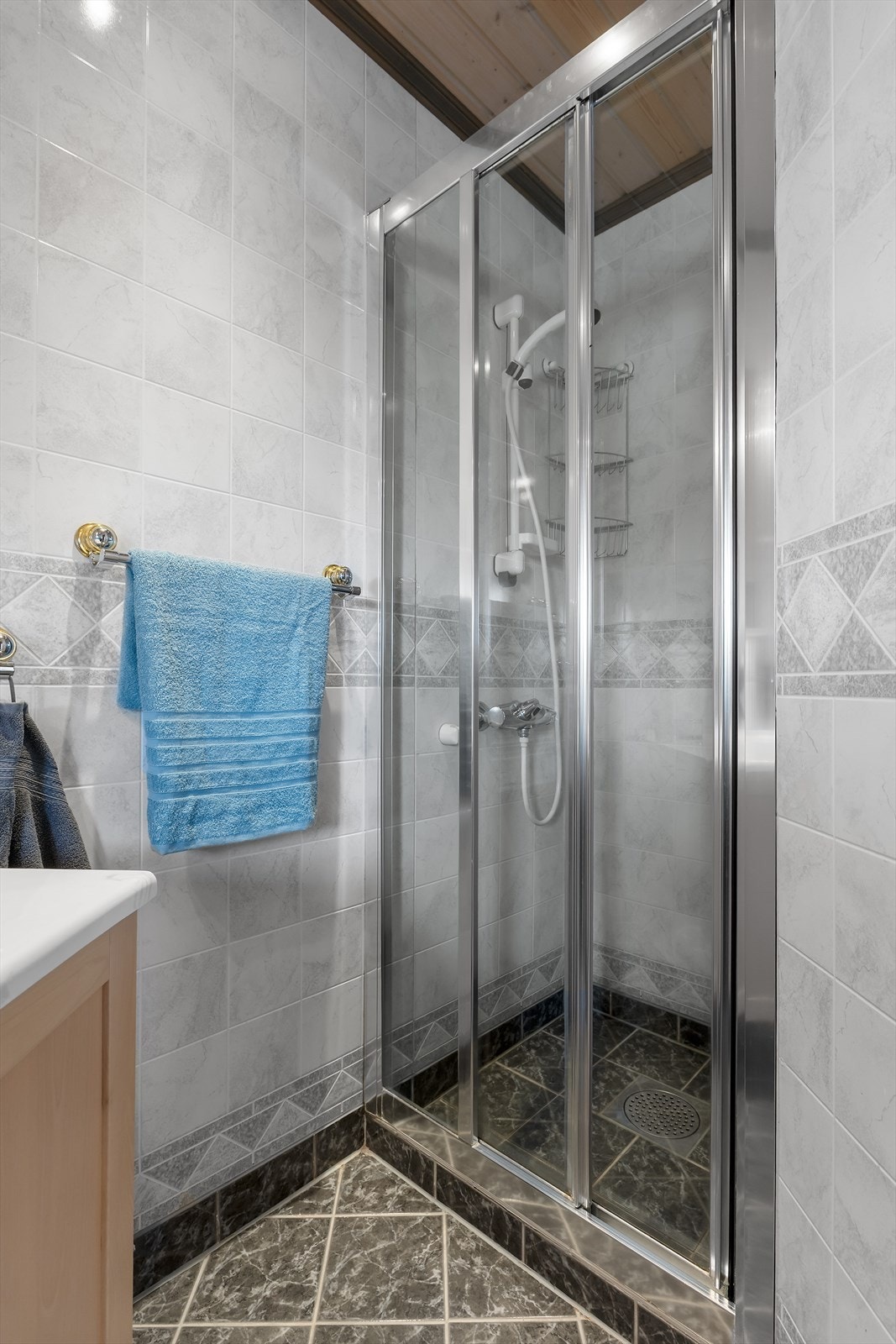 Badet er innreidd med dusjnisje, servant i underskap og klosett Galleribilde