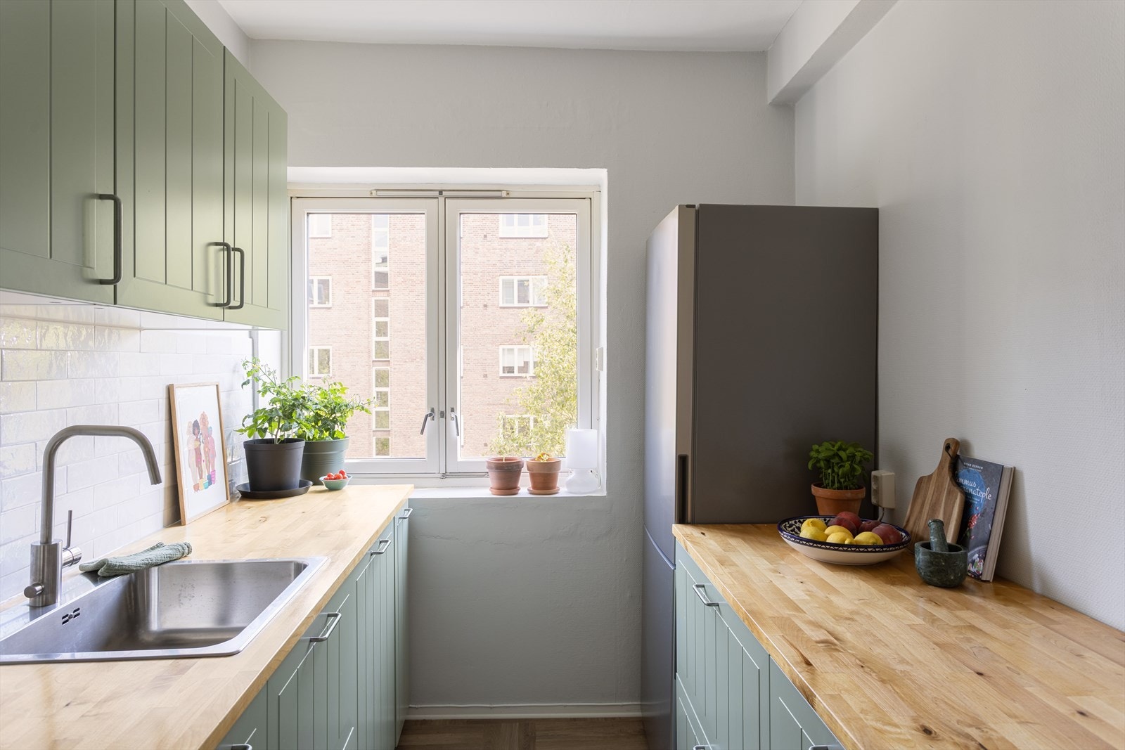 Kjøkkenet har godt med benke og skapplass, og har blant annet benkeplate i tre, integrert oppvaskmaskin og moderne løsninger Galleribilde