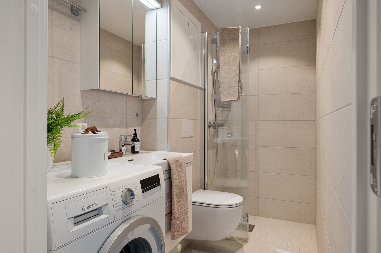 Det er plass til vaskemaskin på badet og det er selvfølgelig varmekabler på gulvet. Galleribilde