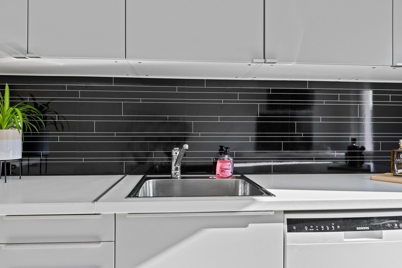 Det er montert sprutplate i laminat over deler av benken og glassplate bak koketoppen for enkel rengjøring Galleribilde