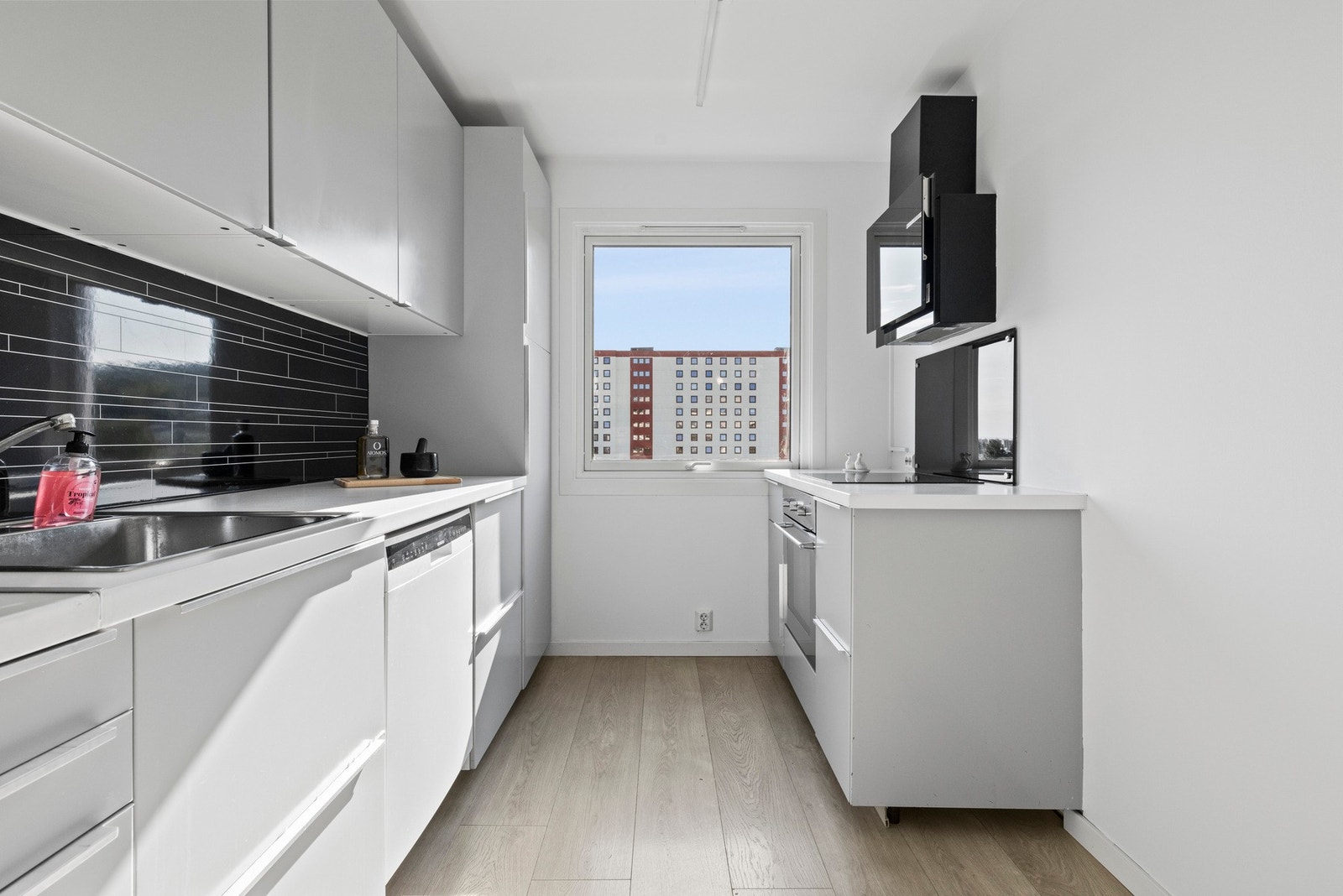 Kjøkkenet er praktisk utformet med slette fronter og overskap som gir god oppbevaringsplass Galleribilde