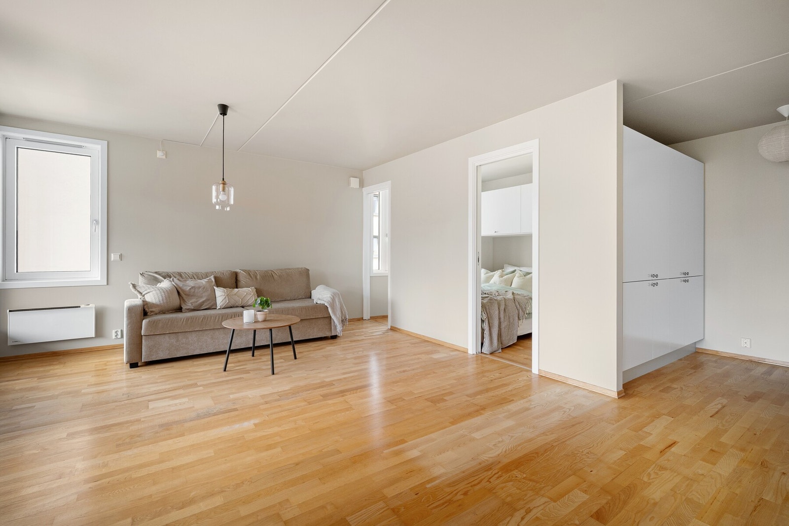 Rommet har en gjennomgående stil med lyse vegger og pent parkettgulv som gir et moderne og innbydende uttrykk. Galleribilde