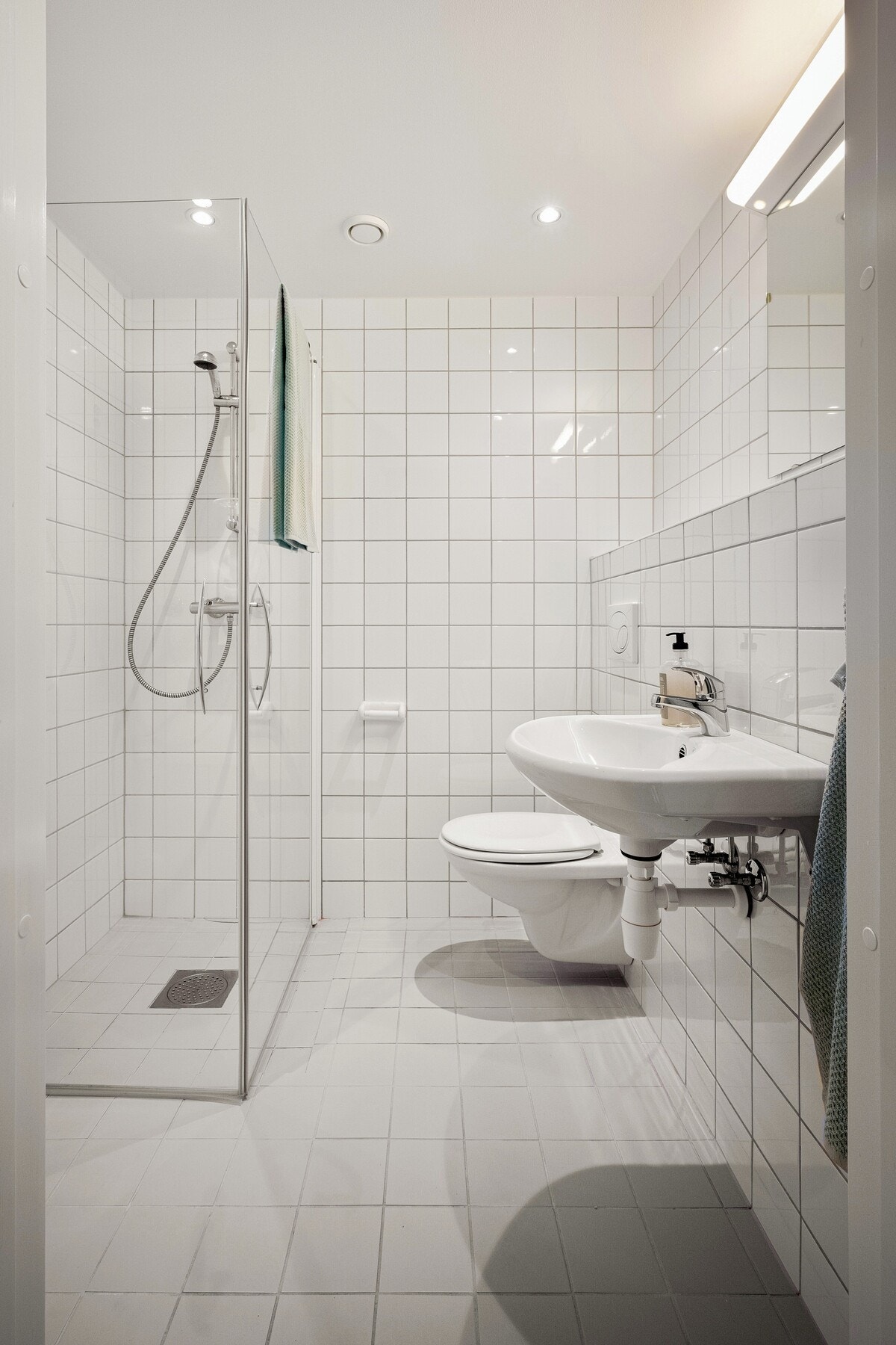 Badet er delikat og funksjonelt, med fliser på både gulv og vegger i lyse farger. Galleribilde