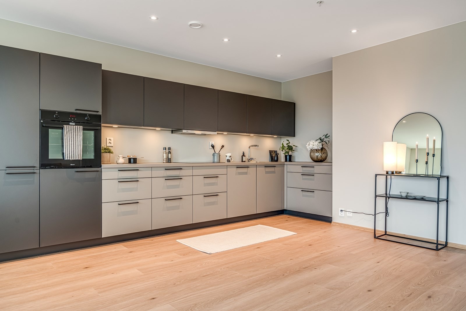 Kjøkkenet er moderne og praktisk, med god skap- og benkeplass. Det har en matt grå finish, og integrerte hvitevarer som kombiskap, oppvaskmaskin, stekeovn og koketopp. Galleribilde