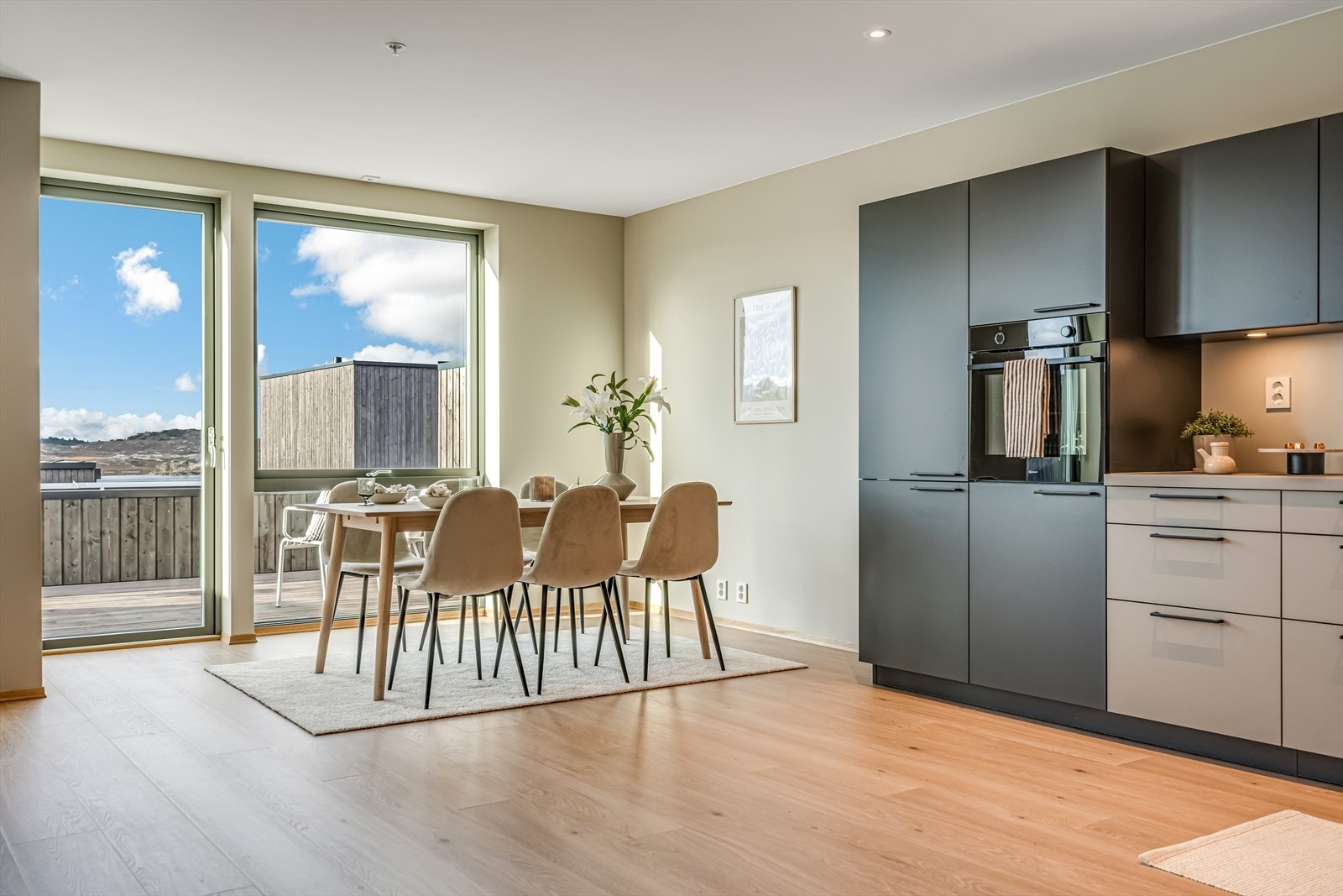 Stuen har åpen kjøkkenløsning som gir rikelig med plass til både sofa- og spisegrupper Galleribilde