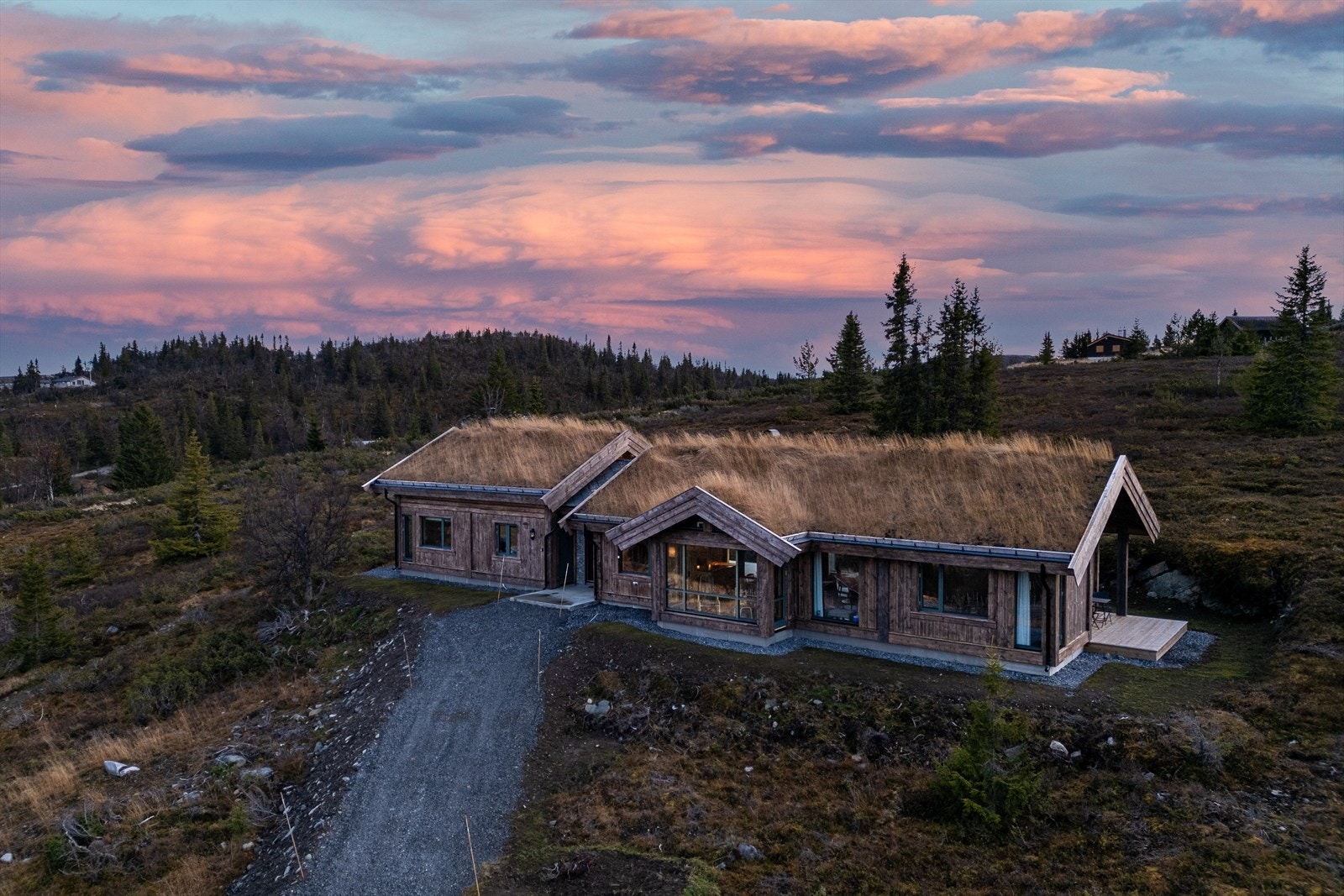 Hytta er oppført med grovt stavlaftpanel, innvendig skjulte takrenner og torv Galleribilde