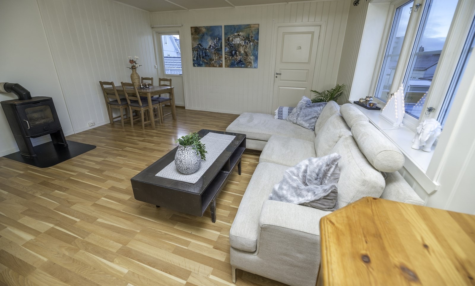 I stua er det plass for både salong og spisestue. Vedfyrt peisovn. Merk: stua er malt i en lys blåfarge og taket er senket med innlagte spotter etter at bildet ble tatt. Galleribilde