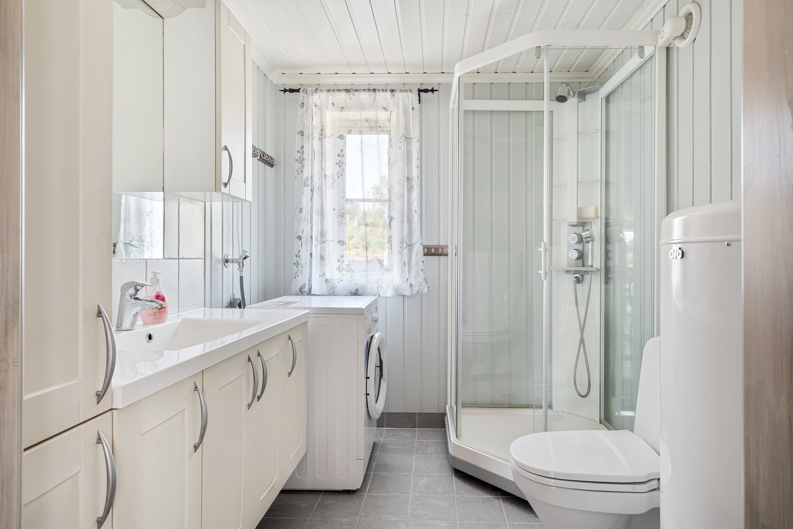 Dagene får en god start på et delikat bad med gulvvarme, dusjkabinett og god skapplass. Galleribilde