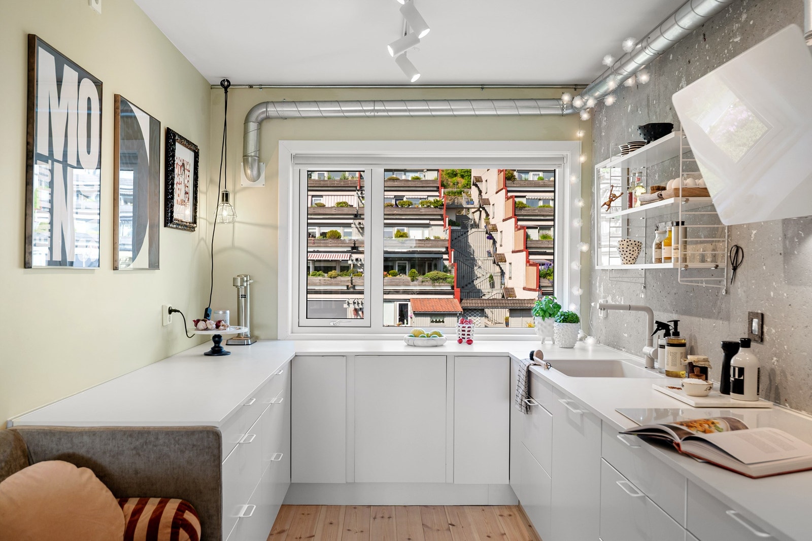 Meget lekkert kjøkken med store vinduer, lyse og moderne farger som harmonerer med boligens fargepalett Galleribilde