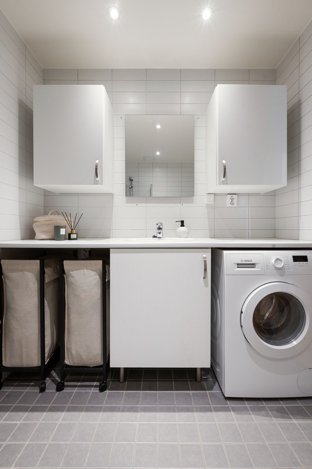 Det er opplegg for vaskemaskin under en praktisk vegg-til-vegg-benkeplate som gir ekstra avlastnings- og oppbevaringsplass. Galleribilde