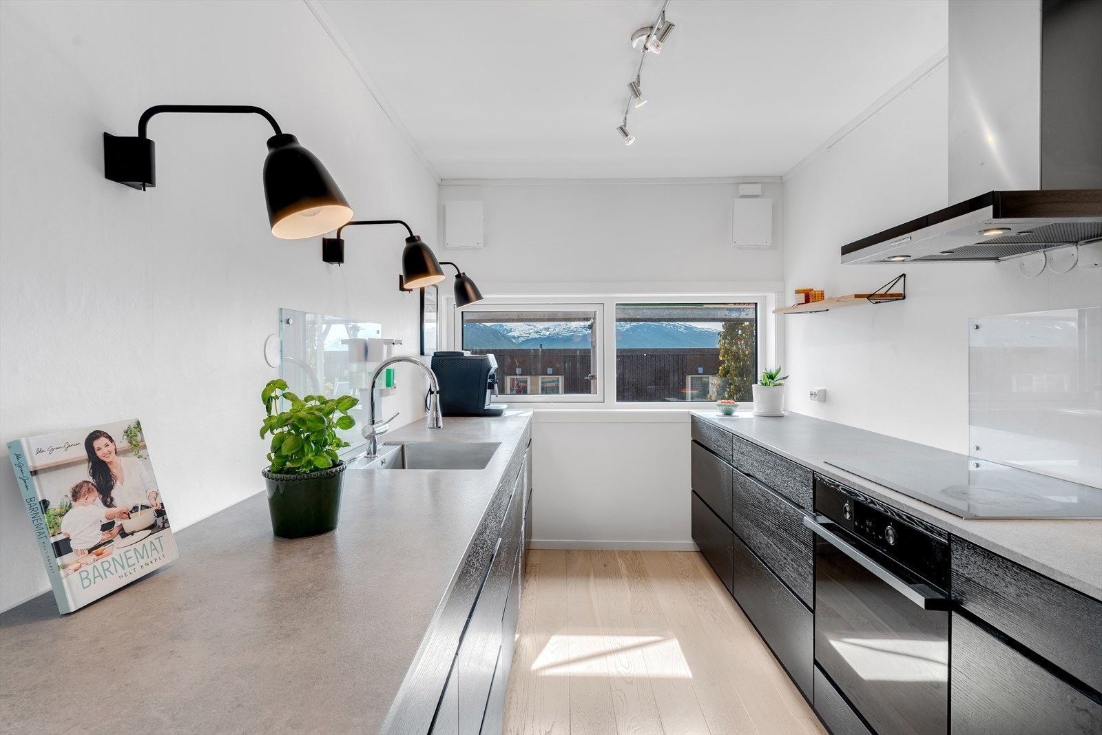Moderne kjøkken i sort utførelse med integrerte hvitevarer. Galleribilde