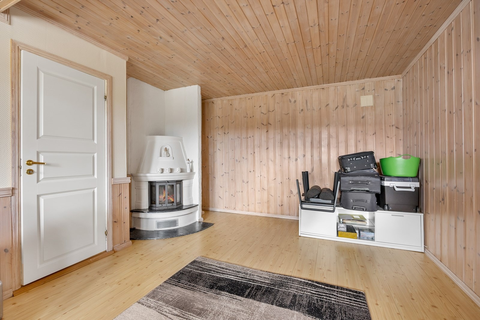 I underetasjen er det en lys og koselig kjellerstue - et kjærkomment ekstrarom for barnefamilier.
Rommet har en hvit elementpeis med innsats for ekstra varme og hygge. Galleribilde