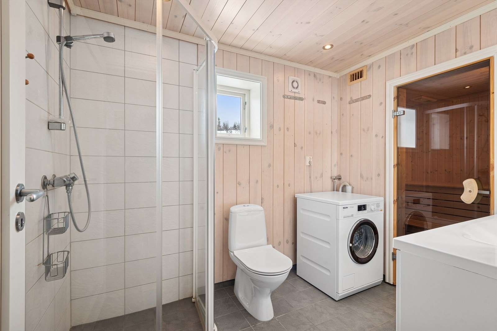 Badet har flislagt gulv med varmekabler, fliser på veggene i dusjsonen og panel på øvrige vegger samt i himling. Galleribilde