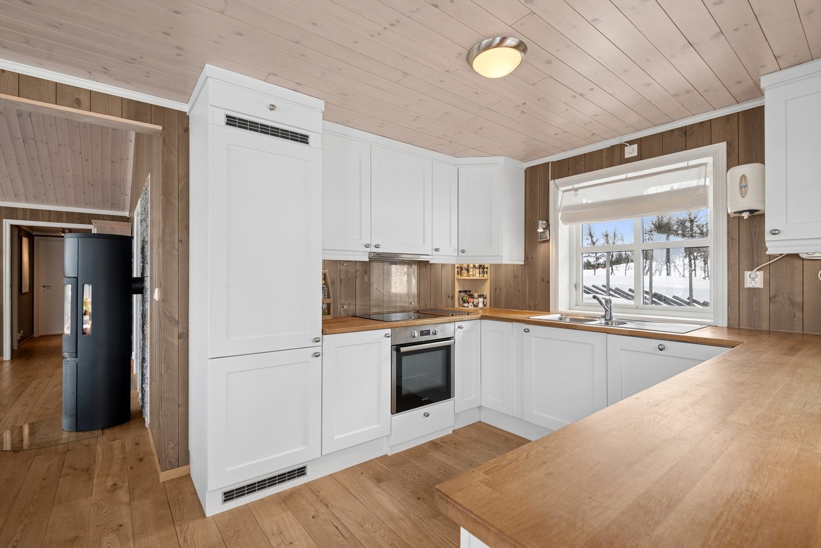 Kjøkkenet ligger i delvis åpen løsning mot stuen. Innredningen har god skap -og benkeplass, med profilerte fronter og heltre benkeplate. Galleribilde