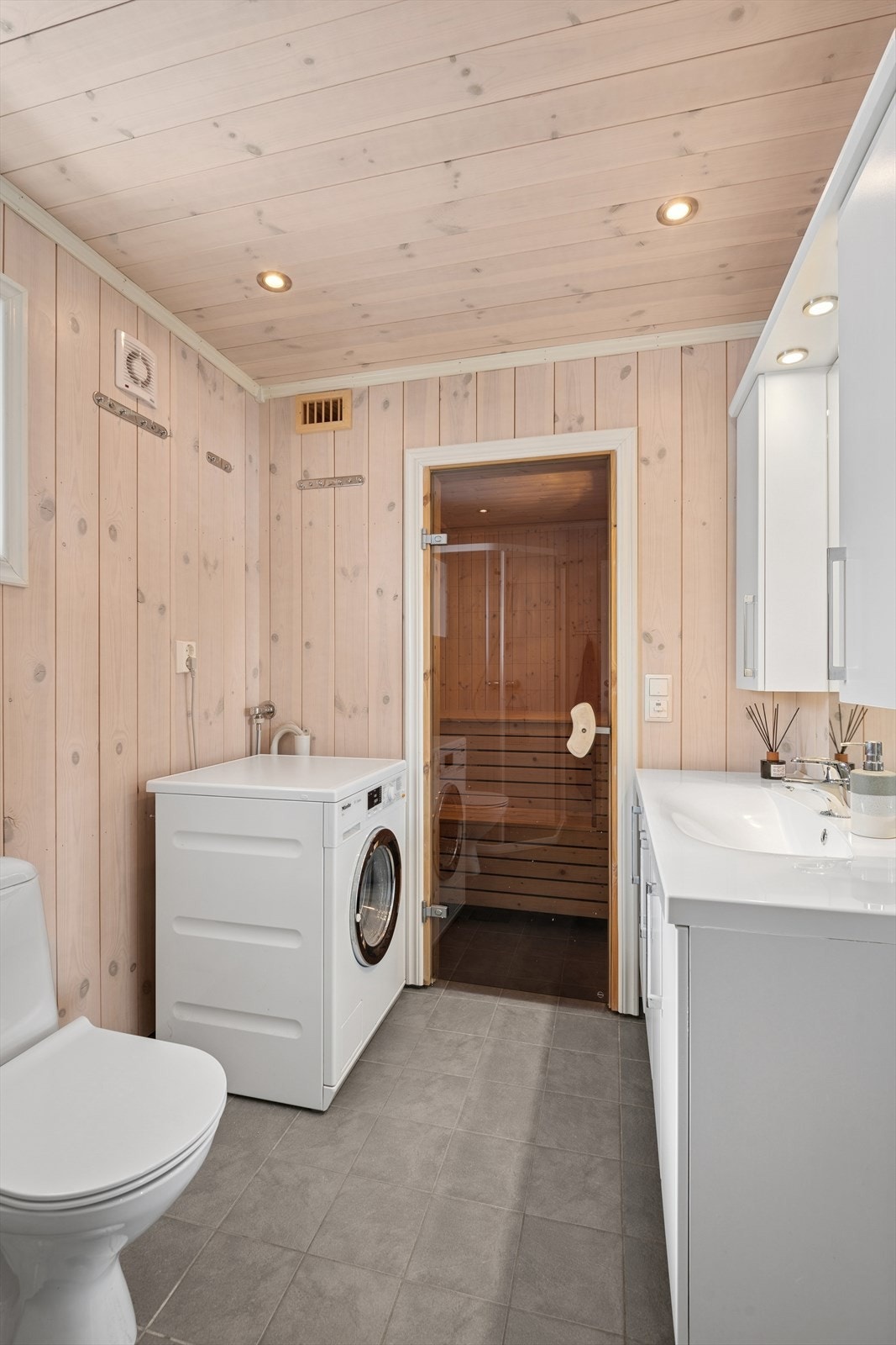 Rommet er innredet med servant med underskap, speil, dusjhjørne og gulvmontert toalett. Galleribilde