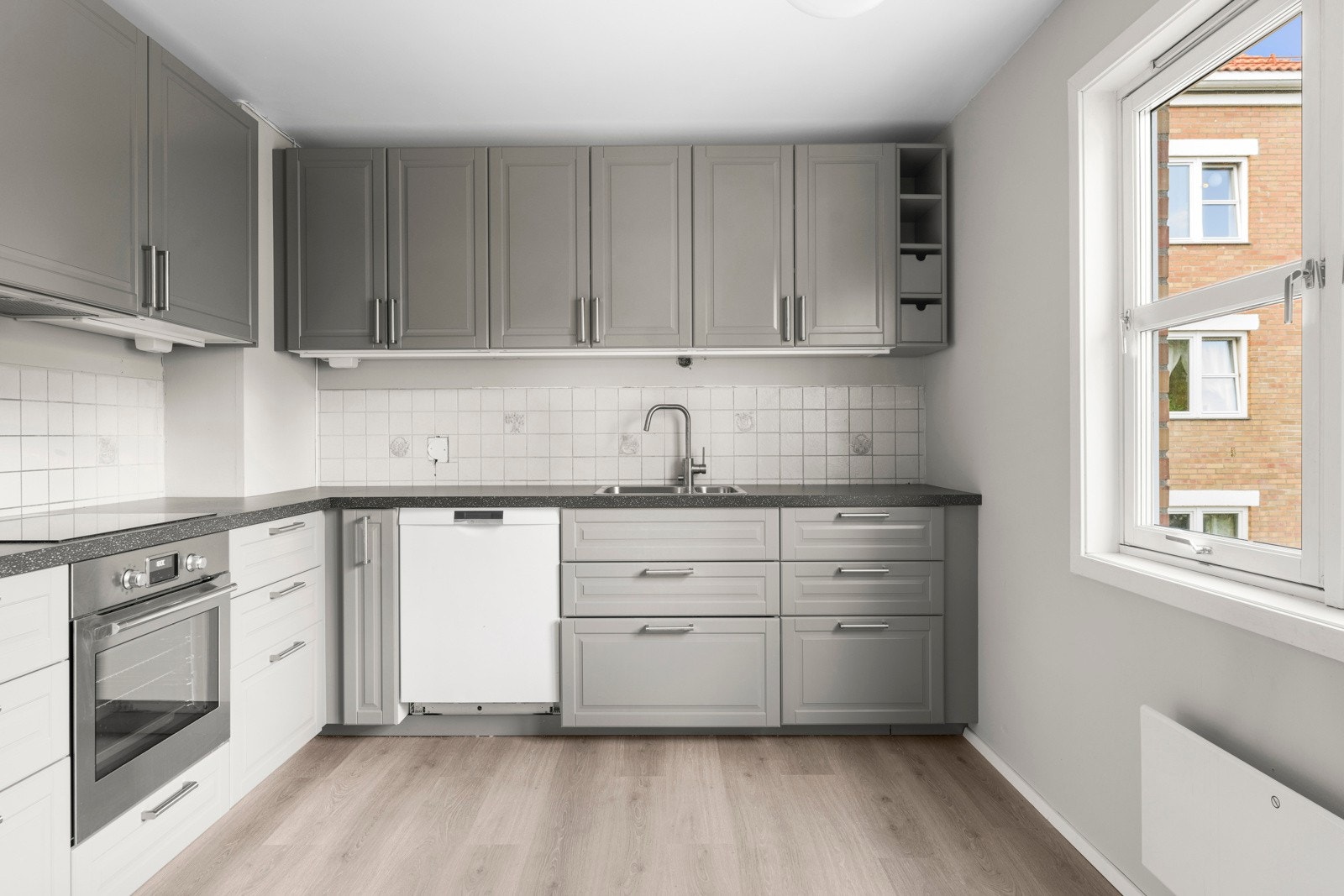 Det er innredning med profilerte fronter, laminat benkeplate og toppmontert kum med ett- greps blandebatteri Galleribilde