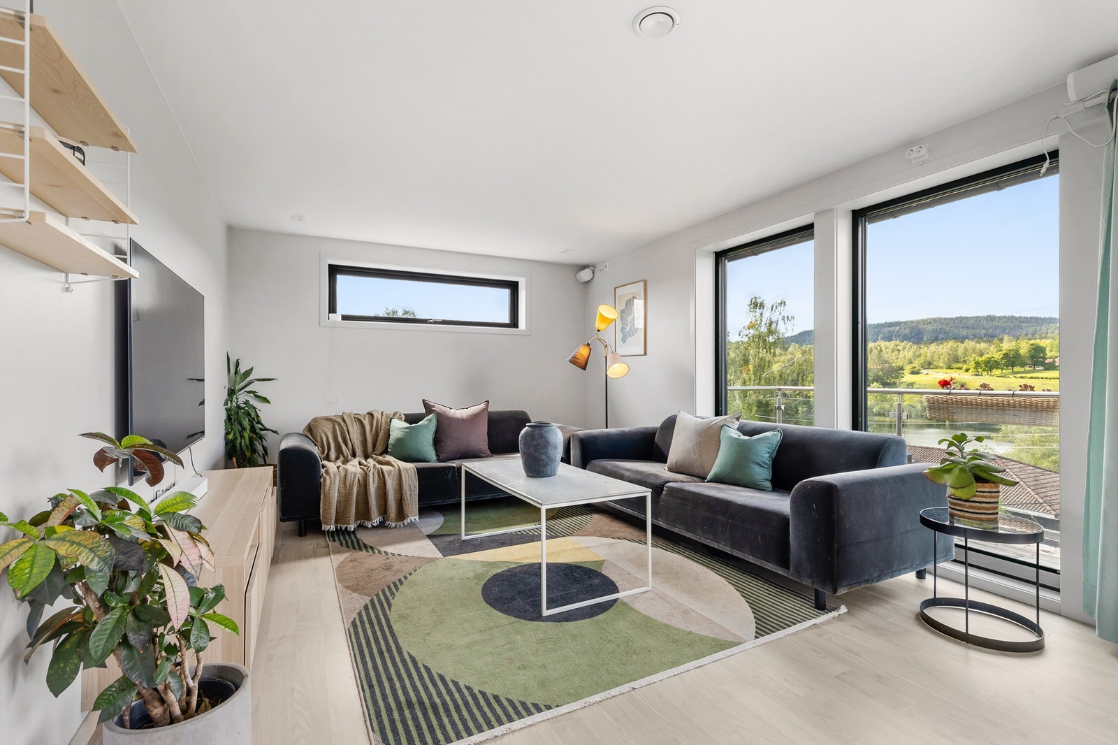 Romslig og lys stue med flere møbleringsmuligheter. Her er det god plass til sittegruppe, TV-område og stort spisebord. Galleribilde