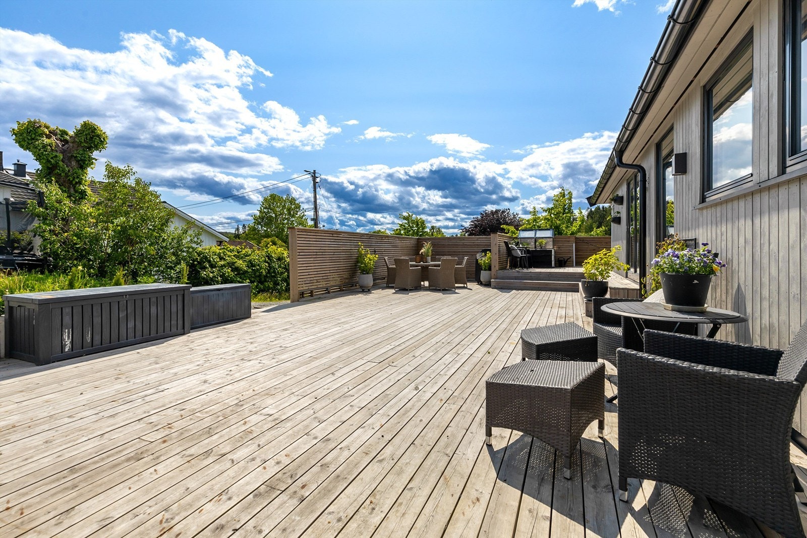 Terrassen går rundt hjørnet av boligen og tillater flere sitteområder med god plass til utemøbler. Galleribilde
