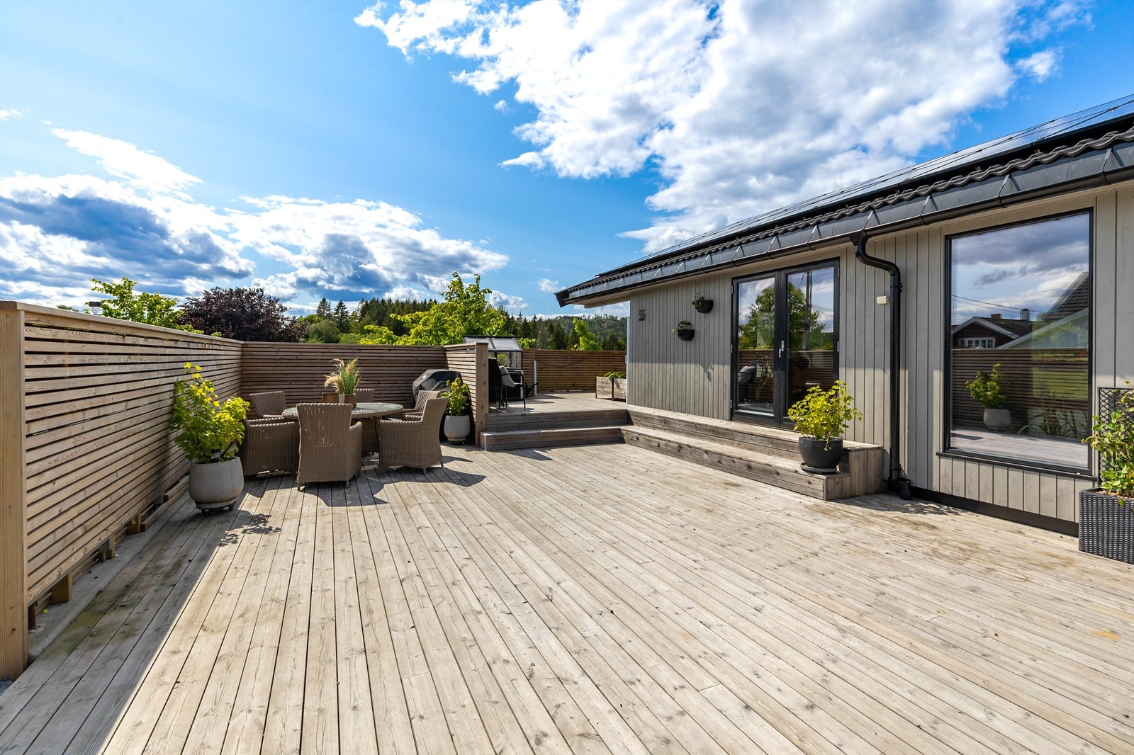 Terrassen går rundt hjørnet av boligen og tillater flere sitteområder med god plass til utemøbler. Galleribilde