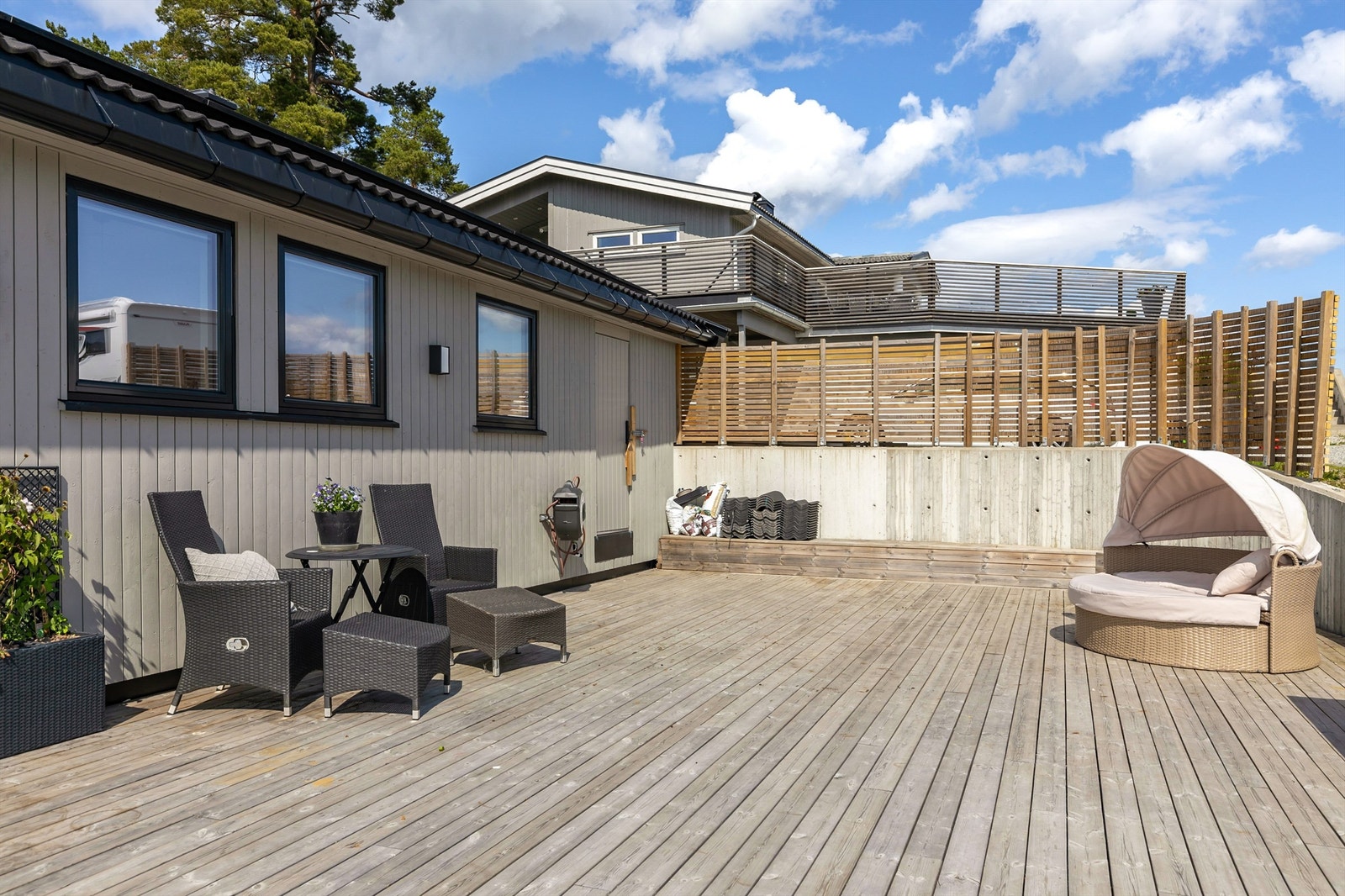 Terrassen går rundt hjørnet av boligen og tillater flere sitteområder med god plass til utemøbler. Galleribilde