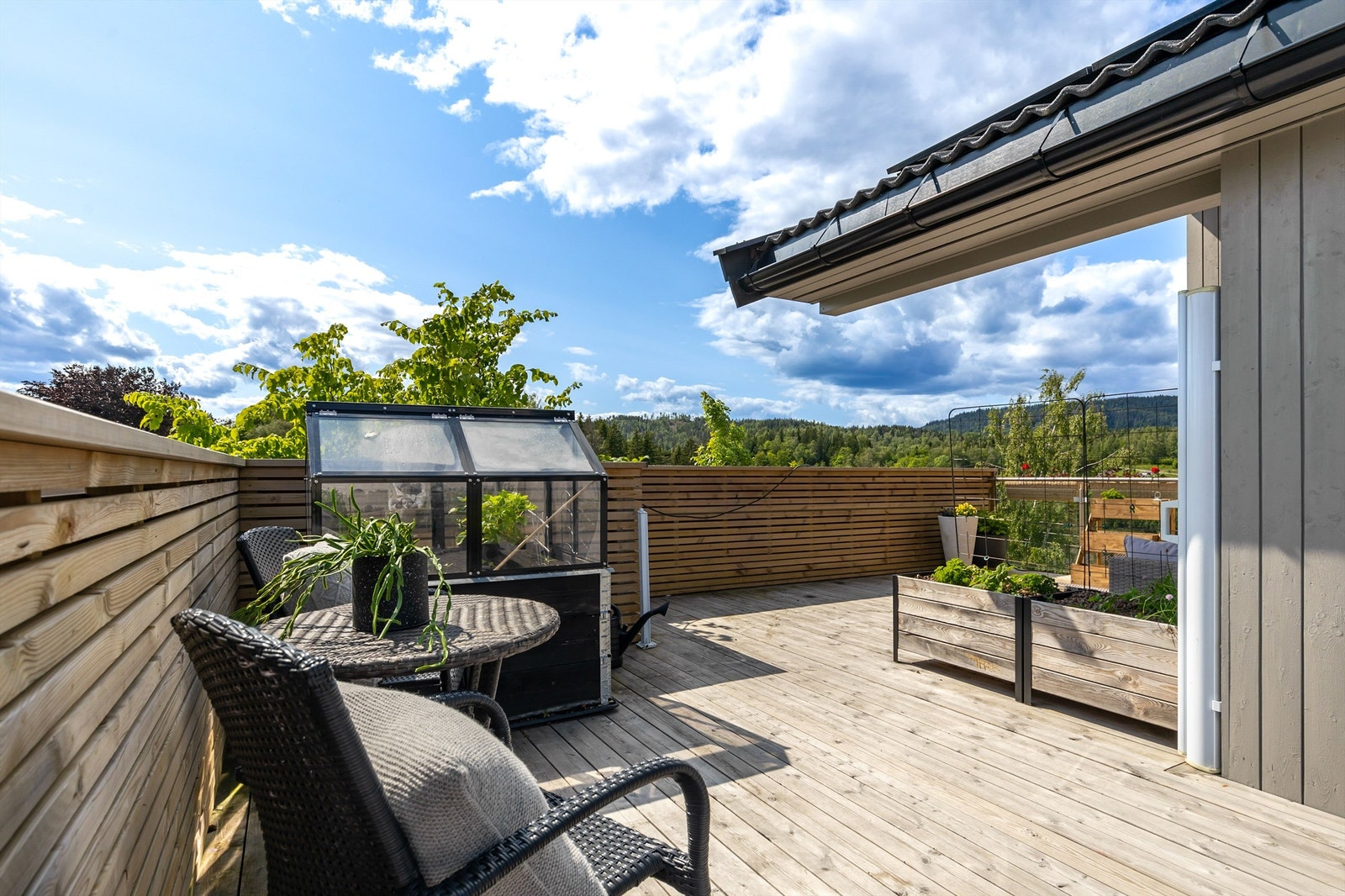Terrassen går rundt hjørnet av boligen og tillater flere sitteområder med god plass til utemøbler. Galleribilde