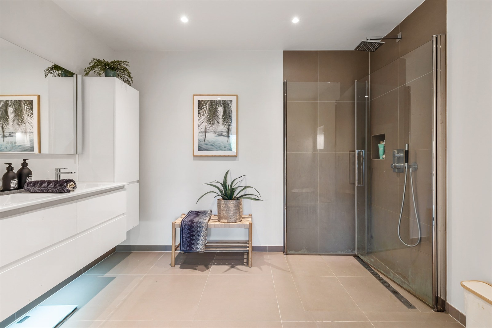 Vegghengt servantskap med skuffer og ovenpåliggende dobbel servant med ett-greps armaturer. Sideskap på vegg. Speil med overlys og stikkontakt på vegg over servant. Galleribilde