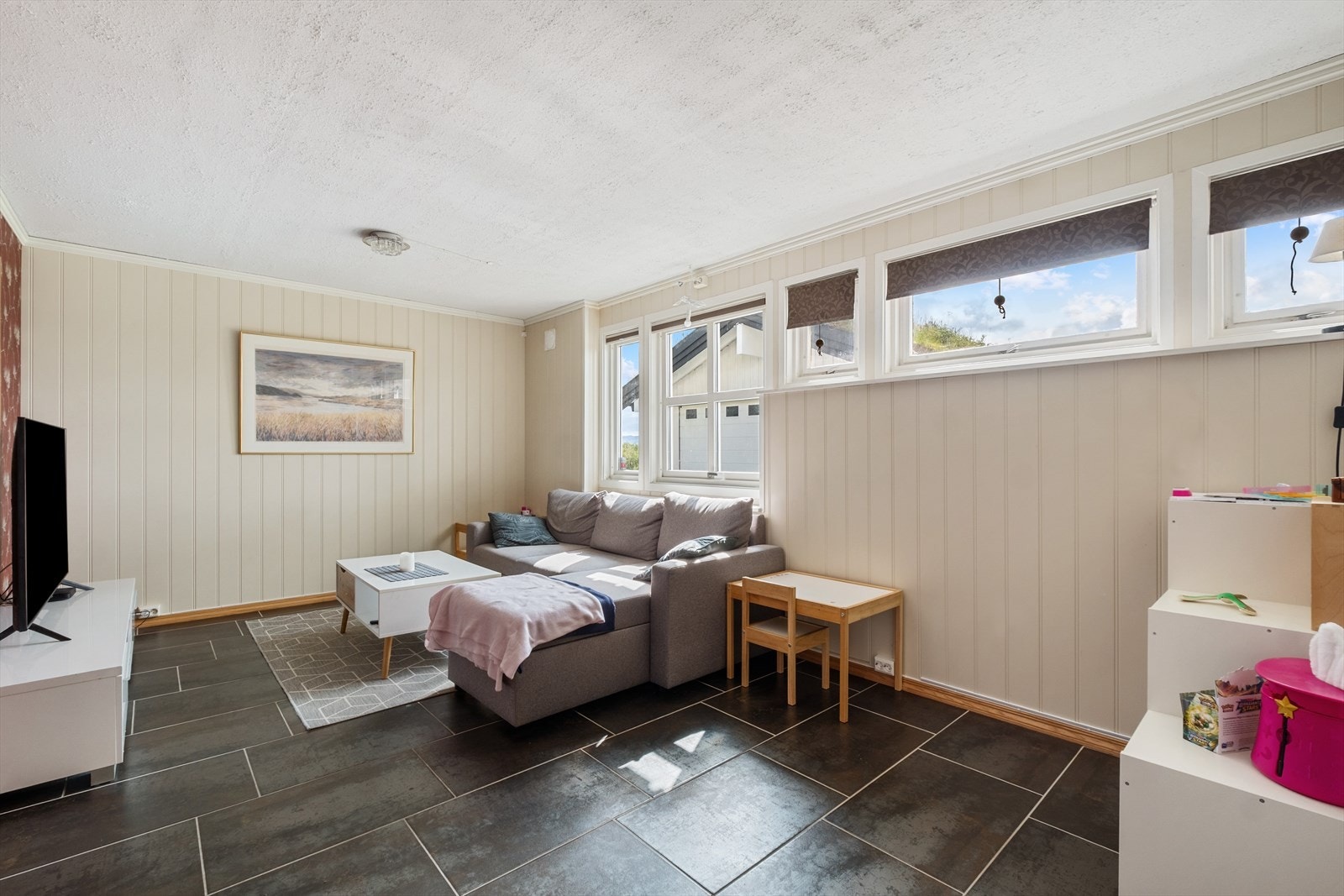 Stue i utleiedel, lyse farger og fliser på gulv. Galleribilde