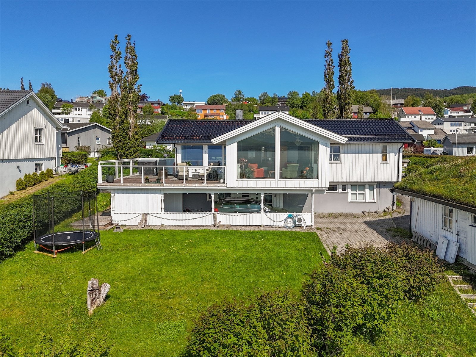 Stor hage på husets sjøside. Adkomst og parkering bi-leilighet. Hage og beplantninger, stor dobbel garasje med ekstra bodplass i garasjens underetasje. Galleribilde