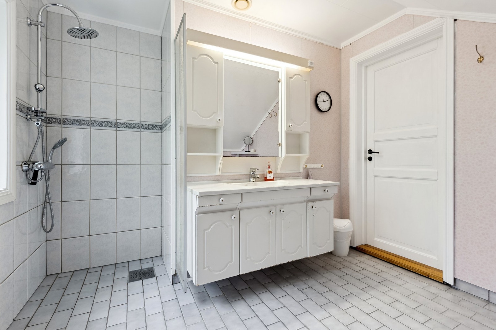 Badet inneholder baderomsinnredning med nedfelt servant, dusj på vegg og gulvmontert toalett Galleribilde