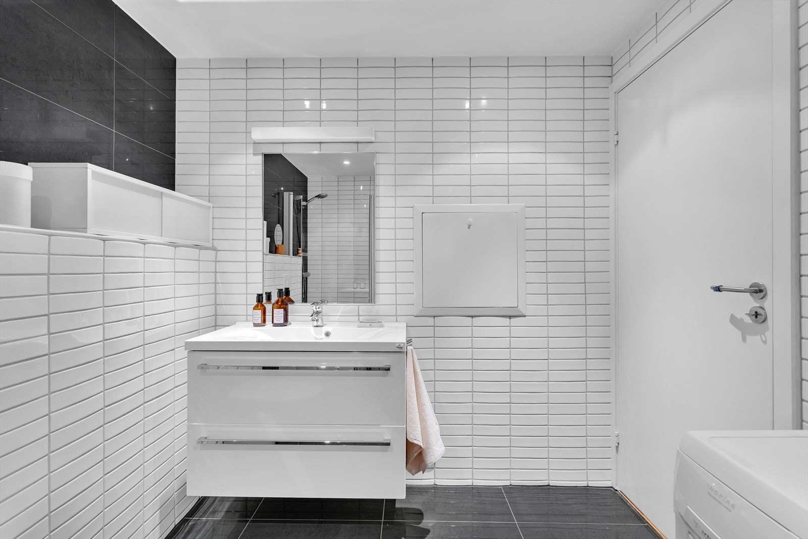 Badet er videre utstyrt med vegghengt toalett, opplegg for vaskemaskin og tørketrommel, samt downlightsbelysning. Galleribilde