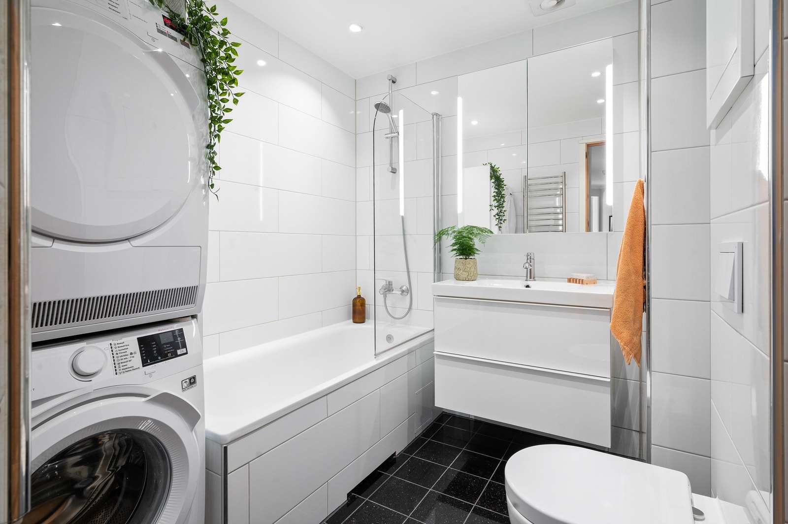 Badet er fra 2019 pent flislagt på gulv og vegger med gulvvarme. Baderomsinnredningen består av vegghengt servantskap med glatte fronter og heldekkende servant. Galleribilde