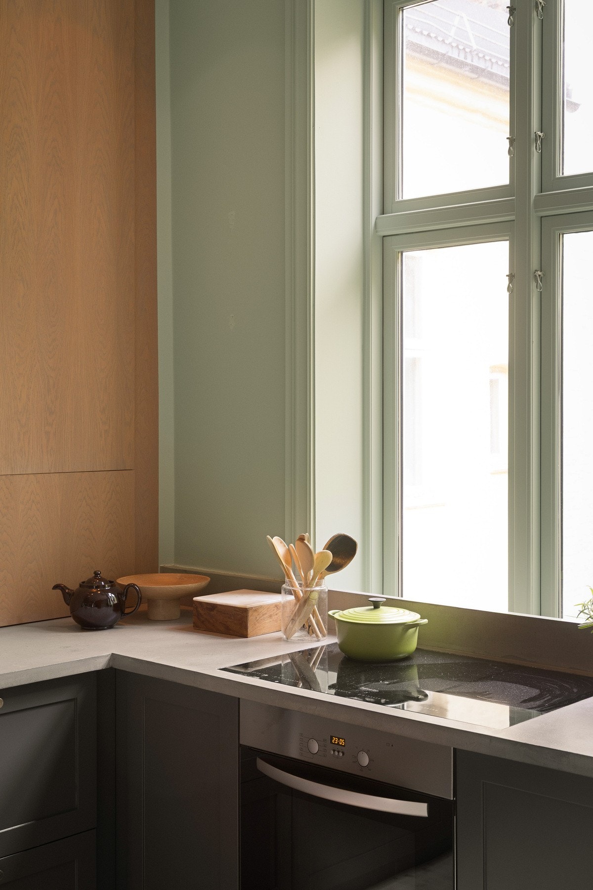 Stekesonen er praktisk plassert foran et stort vindu som gir utsyn mot et frodig og trivelig gårdsrom. Galleribilde