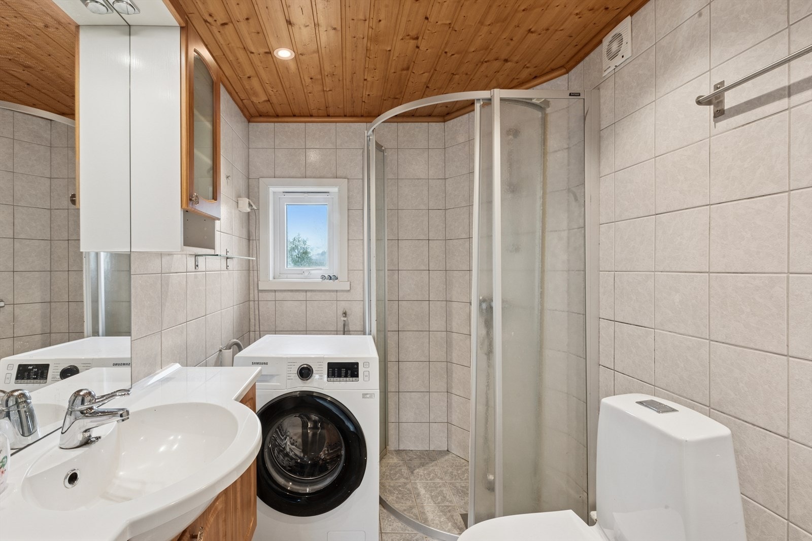 Leiligheten har et eldre flislagt baderom med downlights i himling og opplegg for vaskemaskin. Galleribilde