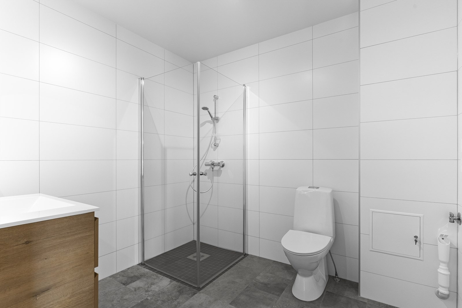 Bad fra byggeår, 2025. Badet består av servant med innredning, varmtvannsbereder, dusjhjørne, toalett og opplegg for vaskemaskin. Galleribilde