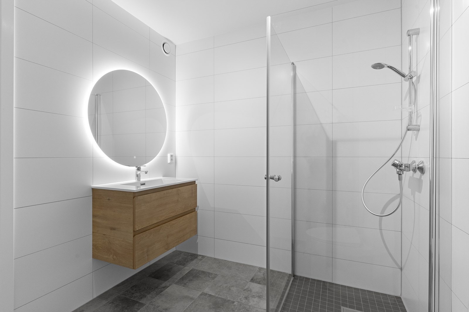 Badet er fliselagt med elektriske varmekabler på gulv og fliselagt på vegger og har malte plater i himling. Galleribilde