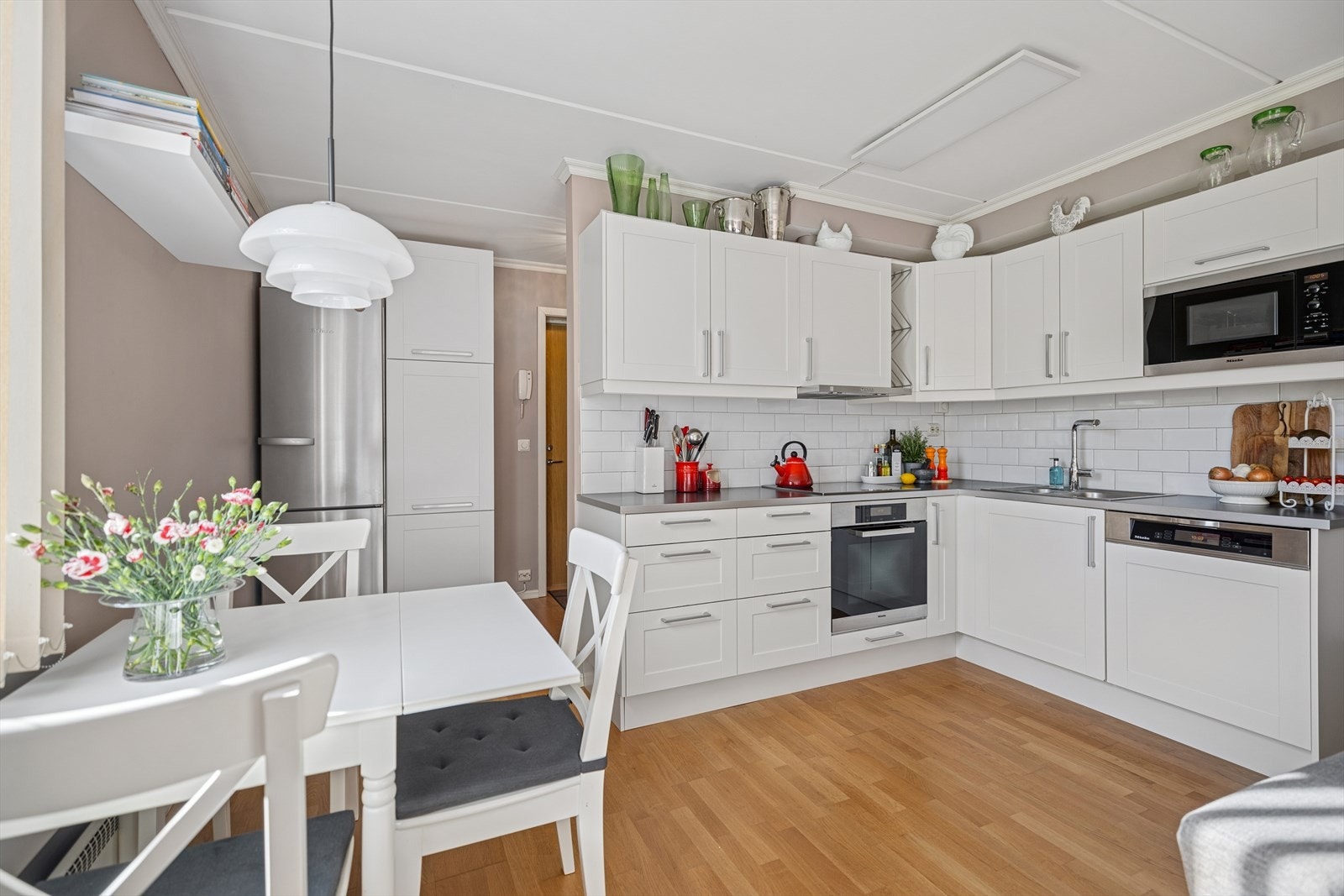Moderne Norema kjøkkeninnredning i hvitt med slitesterk laminat benkeplate og stålkanter. Galleribilde