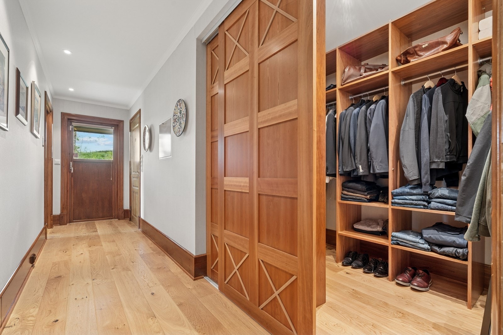 I gangen som tar deg til soverom og bad har eget garderoberom med åpen garderobeløsning Galleribilde