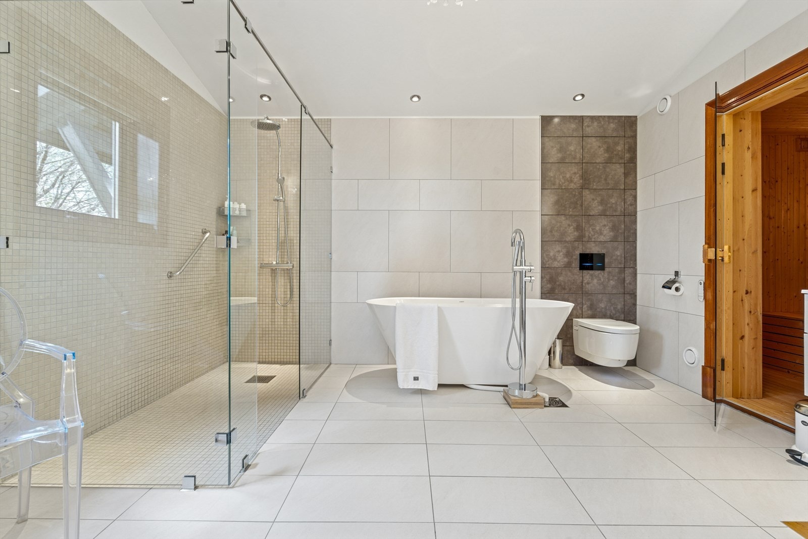 Rommet har stor dusjnisje m/glassvegger og mosaikkfliser - Videre er det vegghengt spyletoalett (fra 2021), badekar og to baderomsinnredninger Galleribilde