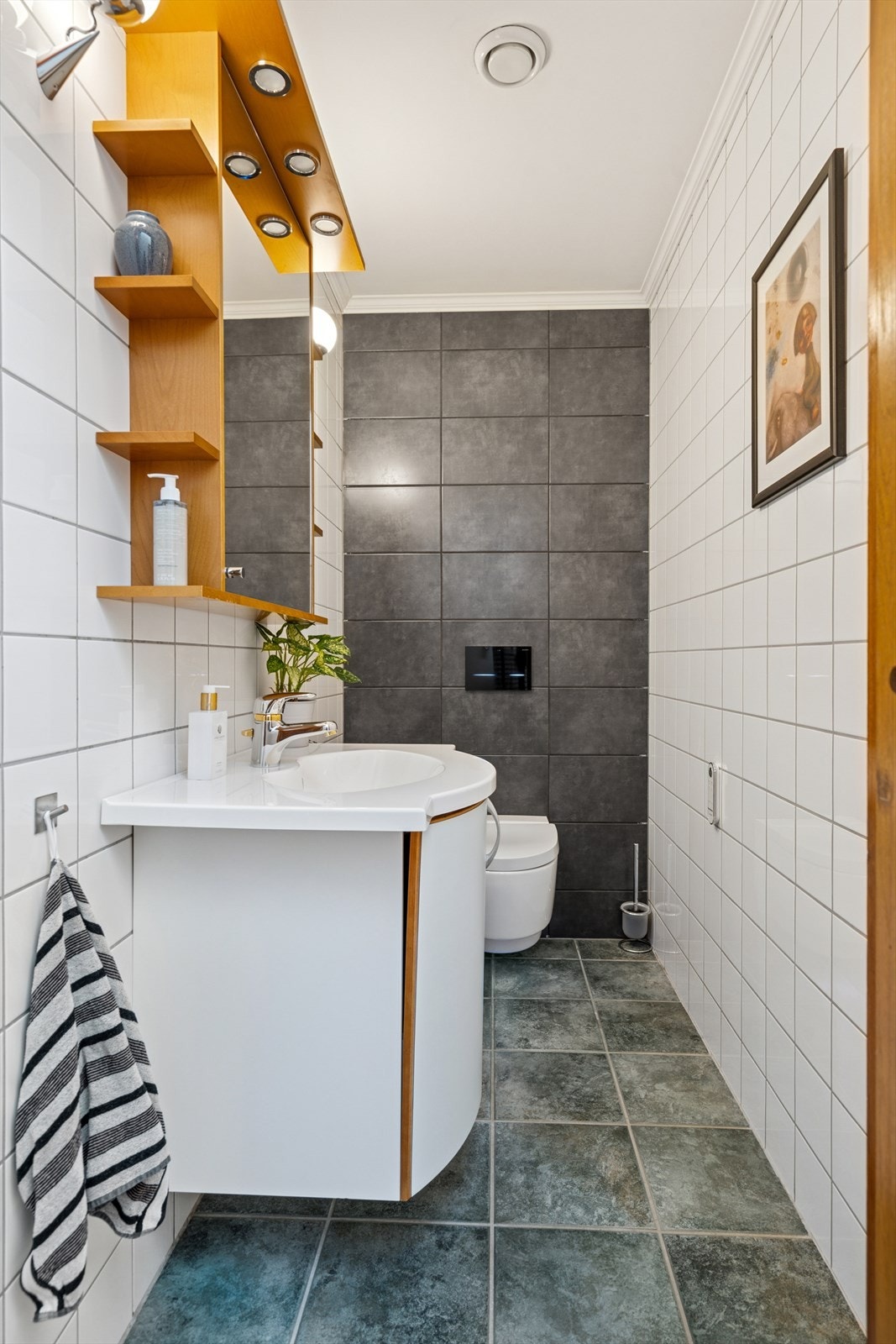 Toalettrommet er strategisk plassert med adkomst fra gangen ved inngangspartiet - Det er flislagte overflater og også her ble det satt inn vegghengt spyletoalett i 2021 Galleribilde