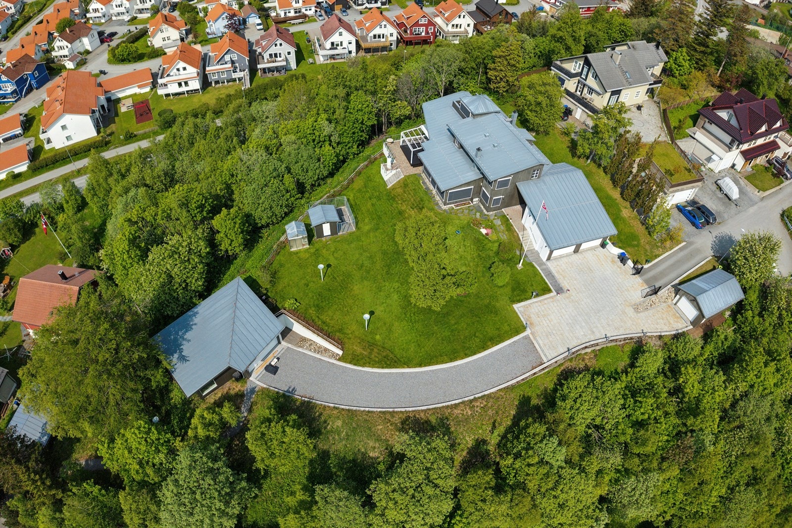 Eiendommen er svært pent opparbeidet med bl.a. gårdsplass belagt med granitt, gruset vei ned til den største garasjen, hundegård, drivhus og en frodig hage med diverse beplantning Galleribilde