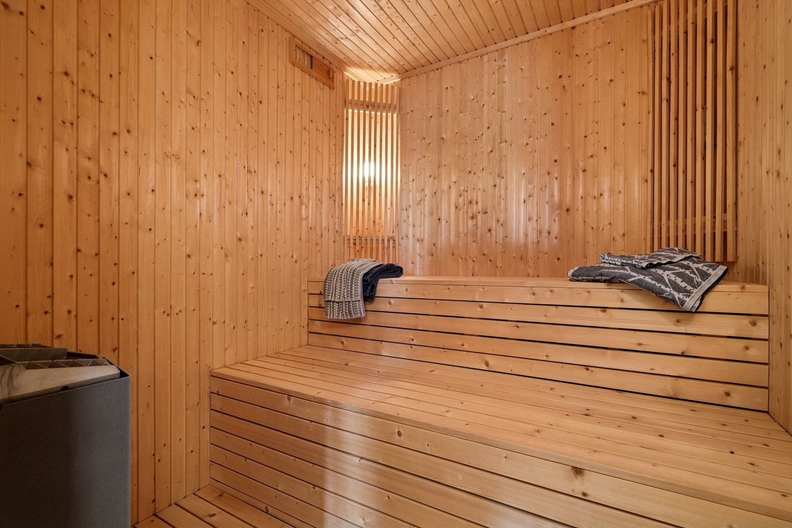 Innenfor badet er det badstue med overflater i grantre og elektrisk vedovn Galleribilde