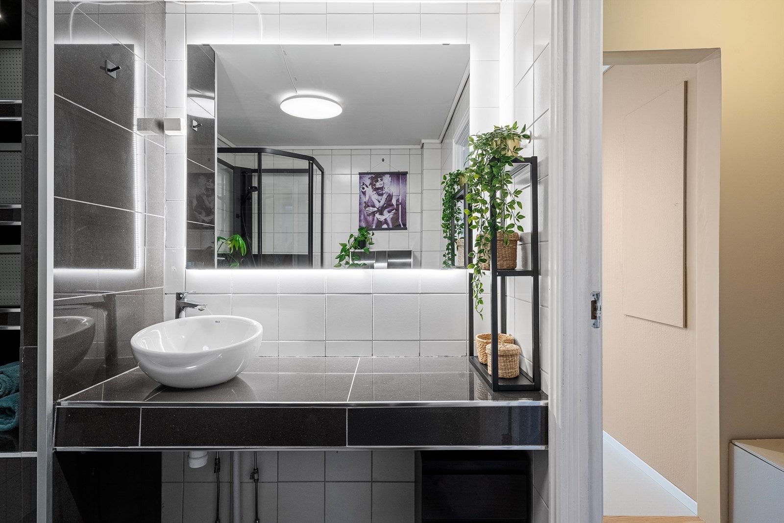 Innredningen består av helfliset servant med overhengende speil, helfliset hylle, vegghengt toalett og dusjkabinett. Galleribilde