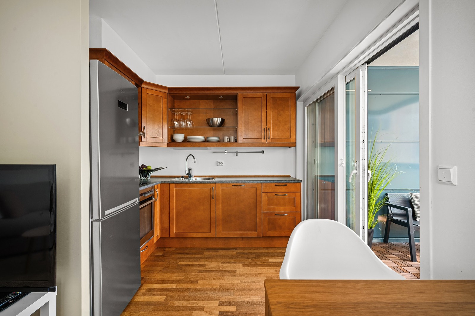 Stue og kjøkken ligger i åpen løsning til hverandre, noe som gir rommet en luftig og sosial atmosfære. Galleribilde