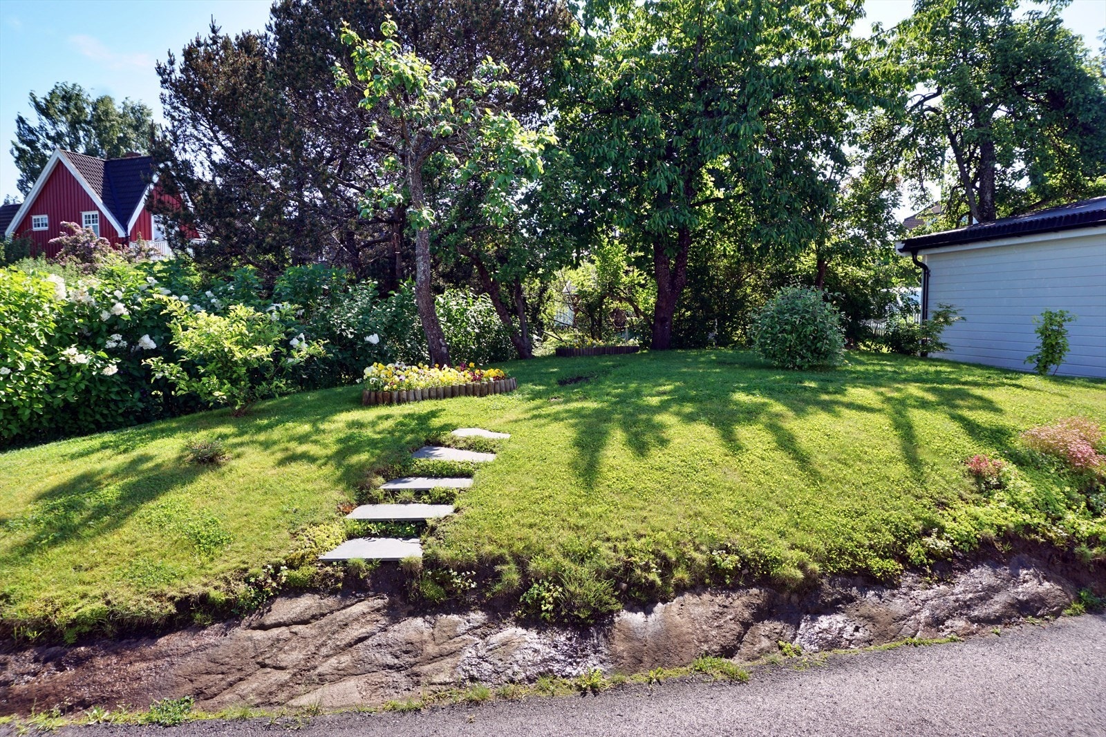 Fin og flott hage men nydelige blomster og busker. Fint å ha en hagefest her for venner og familie Galleribilde