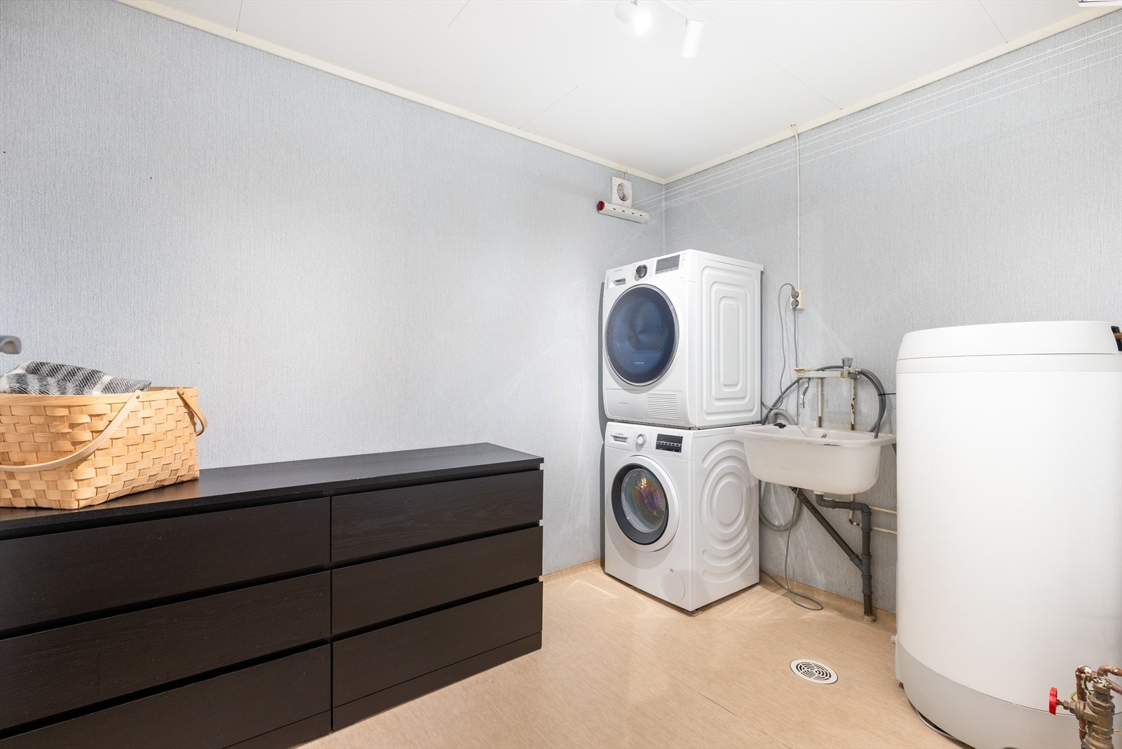 Vaskerommet har våtromstapet på vegger, vinylbelegg på gulv og takess i himling. Her finnes skyllekar, opplegg for vaskemaskin og elektrisk vifte. Galleribilde