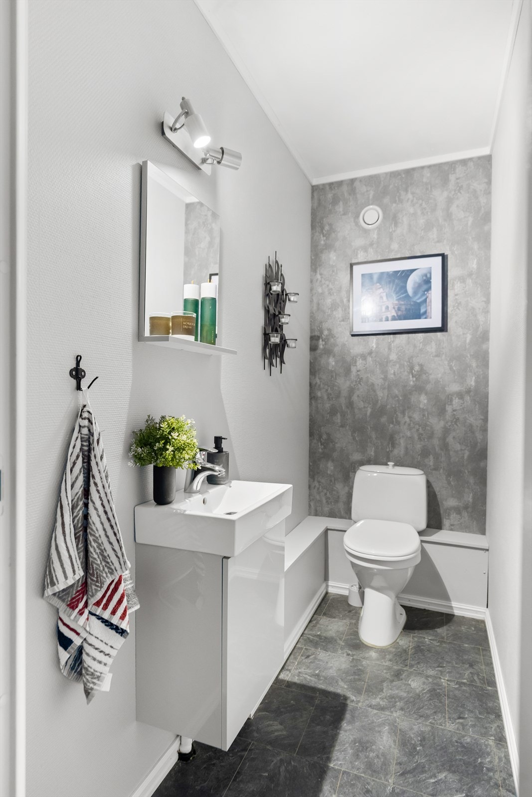 Vegg i vegg med baderommet er et separat toalettrom med servantskap, servant og wc. Galleribilde