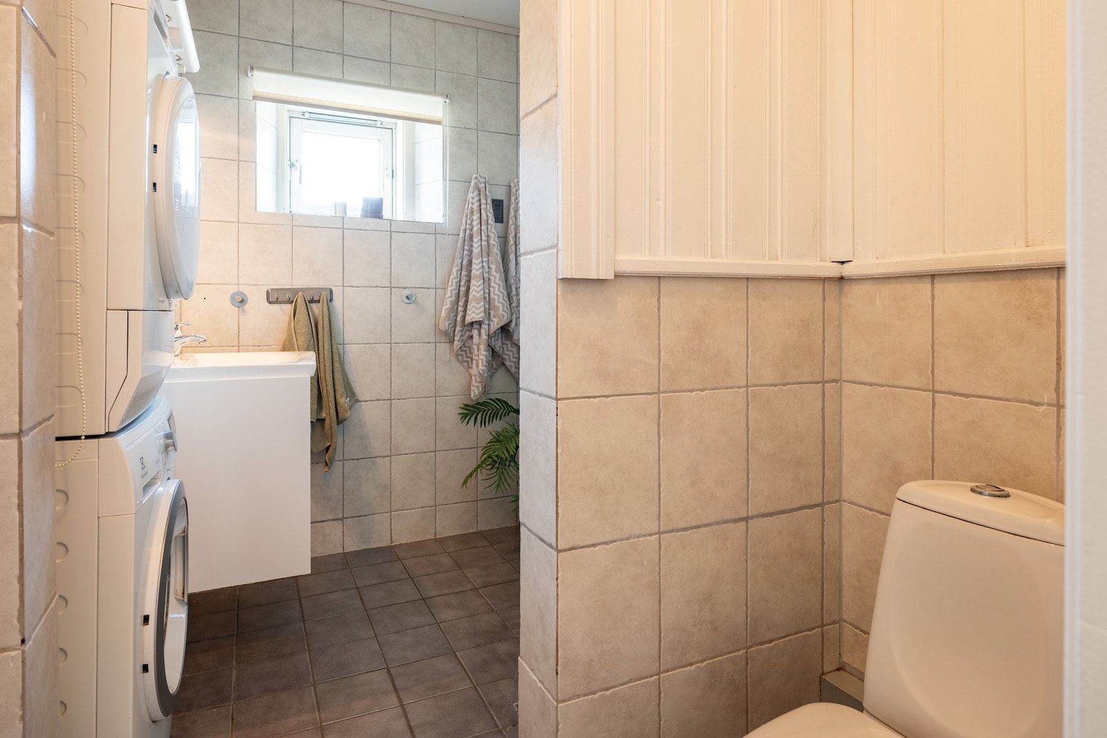 Av utstyr finnes dusjhjørne med glassvegger, toalett, servant med innredning og opplegg for vaskemaskin. Galleribilde